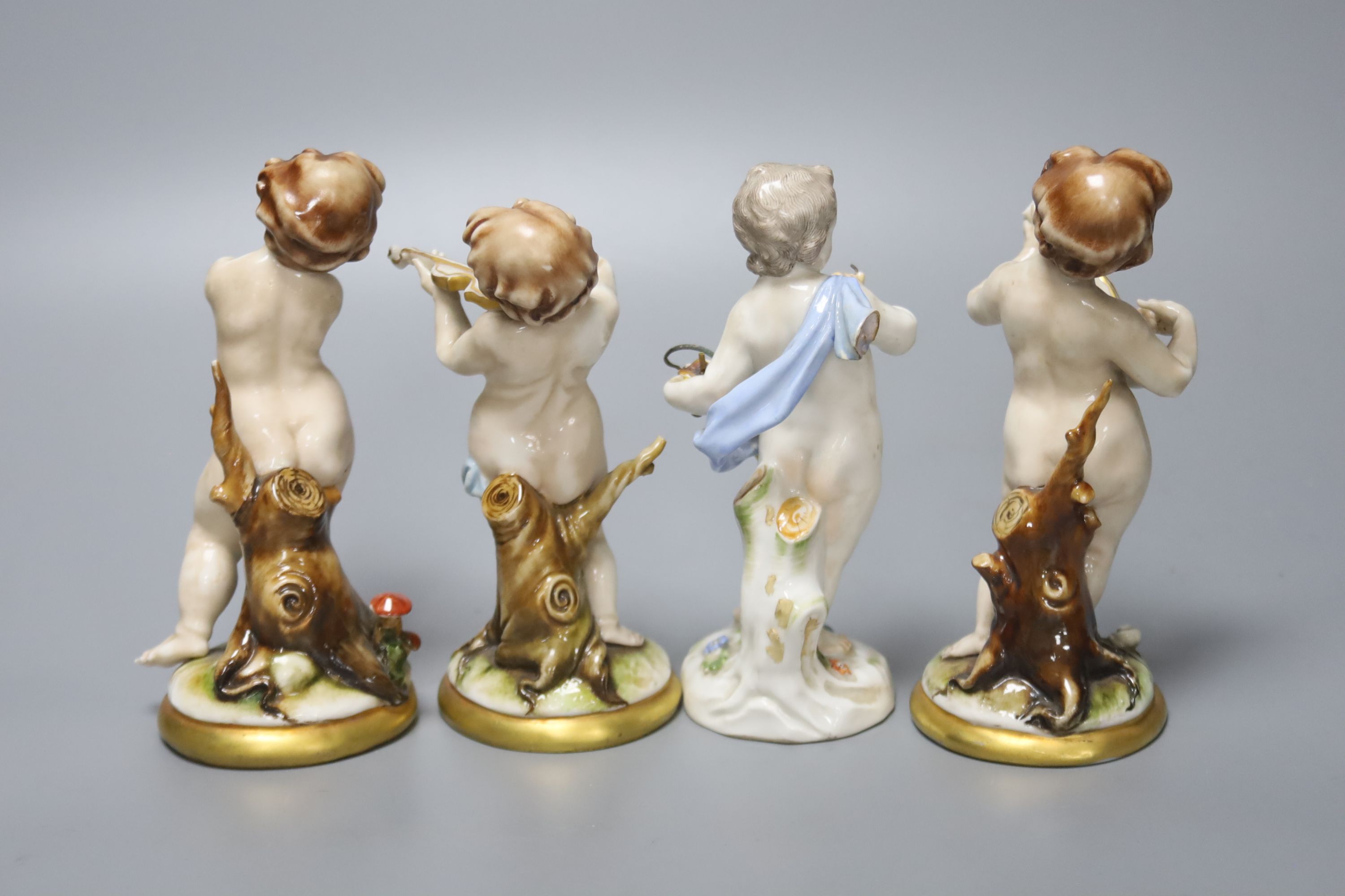 A Meissen porcelain figure of a cherub together with three Continental porcelain cherubs, height 14cm